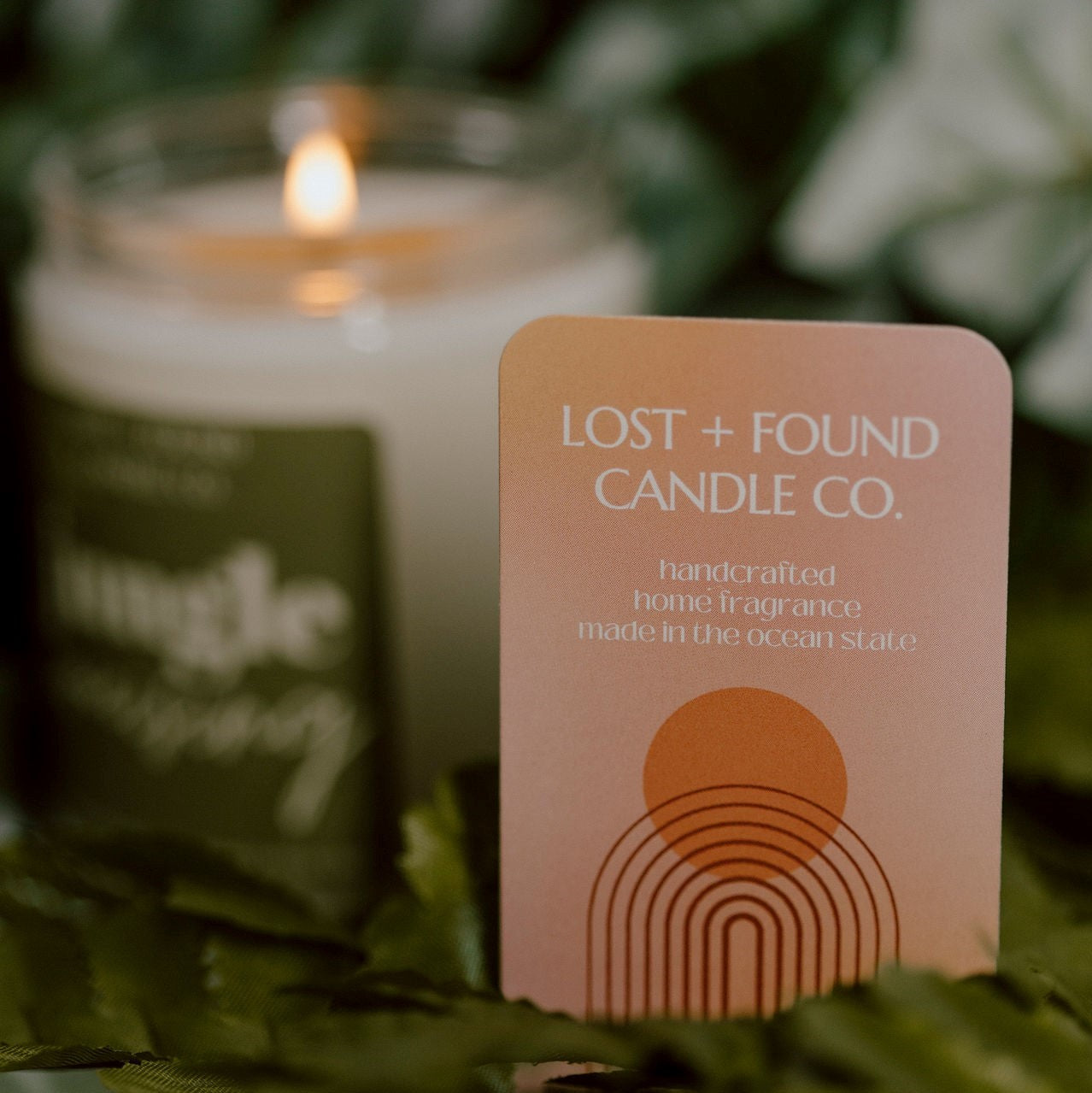 Lost and Found Candle Co. business card in front of Jungle Cruising candle